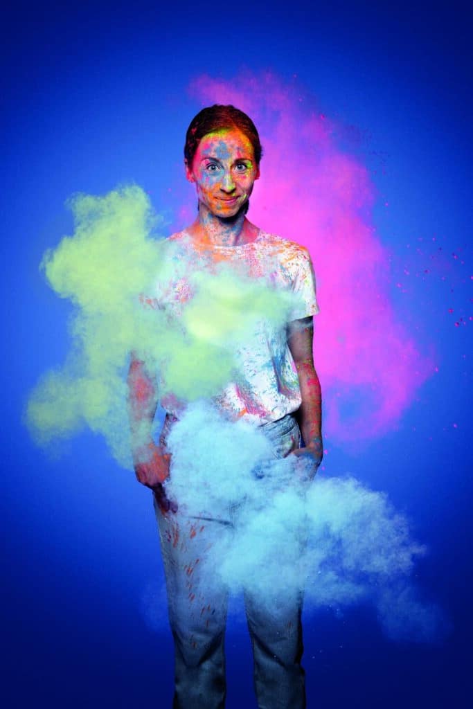 Portrait d’une femme dans un nuage de poudres colorées